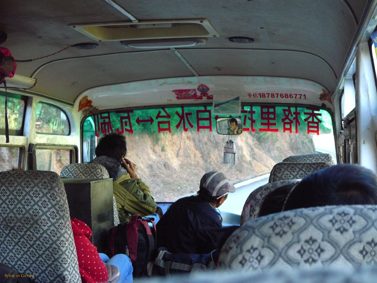 075 Shangri La dans le bus le chauffeur entre la cloppe et le portable négocie les virages 